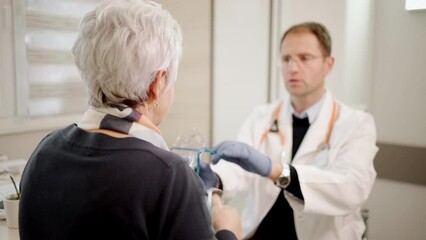 Doctor specialist having a session with patient. Senior lady at clinic checking her health. Medic measures a blood pressure and temperature. Seasoned female person getting a vaccine. 
