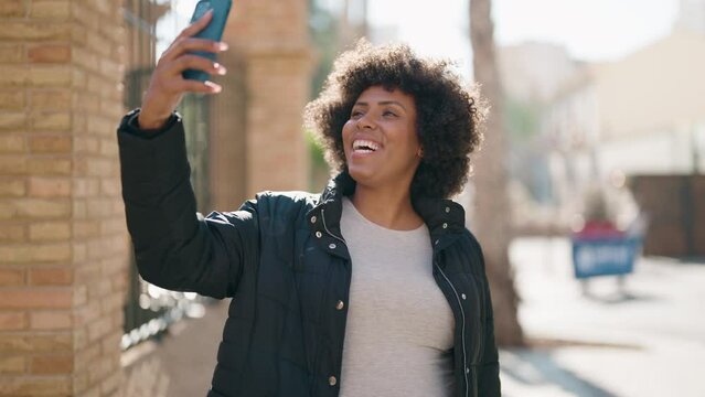 Young african american woman smiling confident making selfie by the smartphone at street