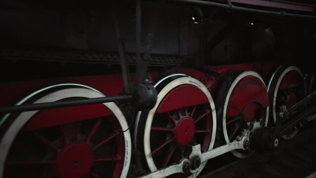 Old wheels and parts of a steam engine close-up. Soviet locomotive stands