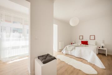 Bedroom with king size bed with white walls and furniture and wooden floors