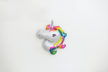 Fototapeta na wymiar Inflatable unicorn hanging on the wall for birthday decoration