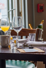 Restaurant Table Top at the End of a Meal with Glasses, Napkins, Clipboard and Check.