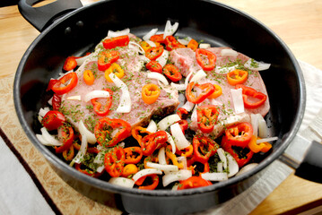 Raw Pork Chops in a Pan with Onion and Mini Sweet Peppers 