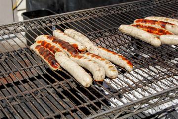 A view of several bratwurst on the grill.
