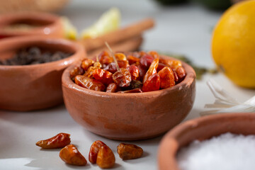 A closeup view of a condiment cup of pequin chile.