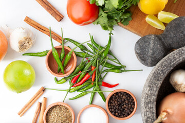 A top down view of a pile of bird's eye chili peppers, or Thai chilis.