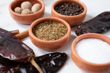 A view of a condiment cup of dried oregano flakes, among other herbs and spices. 