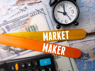 Top view calculator,banknotes and clock with text MARKET MAKER on wooden background