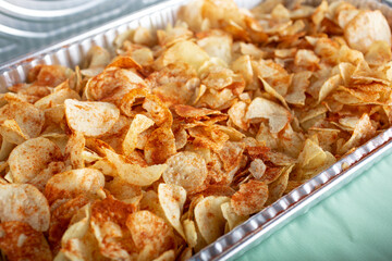 A view of a catering size tray of seasoned potato chips.