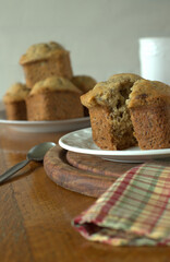 Banana muffins with a slice of butter with dark and white background on a wooden table