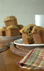 Banana muffins with a slice of butter with dark and white background on a wooden table