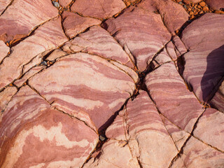 Red-and-white patterned sandstone broken by smoothly eroded cracks