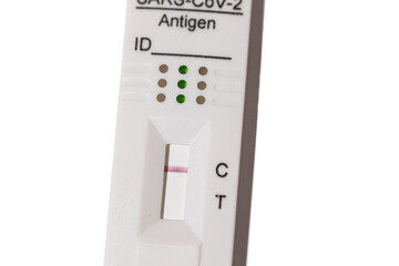 Detail of an antigen test with a red stripe, giving a negative result for covid-19, on a white...
