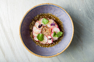 Tuna tar tar with avocado and ponzu sauce on grey table top view
