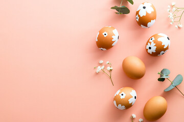 Elegant Easter flat lay composition. Colorful Easter eggs and flowers on pastel pink table. Happy Easter concept. Minimal style.