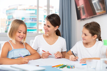 Portrait of single mother with two daughters drawing and having fun