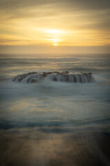Obraz premium ocean sunset waves on rocks