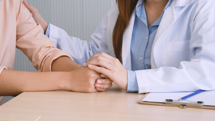 Close up hands Woman doctor holding hands patient encourage cheer up consultation at hospital medicare clinic. Doctor talking to patient support giving hope mental health therapy consoling recovery