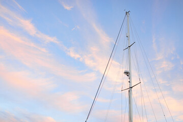 Low angle view of the mast of a sloop rigged yacht. Soft sunlight, glowing sunset sky....