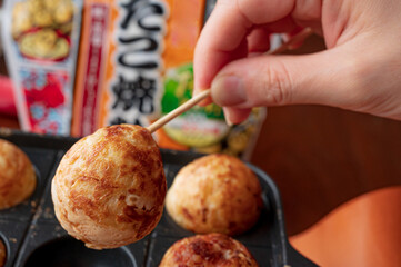 タコ焼き器, 竹串, 半熟, 半円, ひっくり返す, 返し, 突く, タコ焼き機, 揚げ玉, 紅生姜, 蛸焼き, キャベツ, 生地, 焼く, カセットコンロ, たこ焼きプレート, グリル, 鉄鍋, タコ焼き用, ダイニングテーブル, 背景, 爪楊枝, バックグラウンド, 広告, 宣伝, 明るい, 自然光, コピースペース, テキストスペース, 料理, 材料, 素材, blog, ブログ, コメント