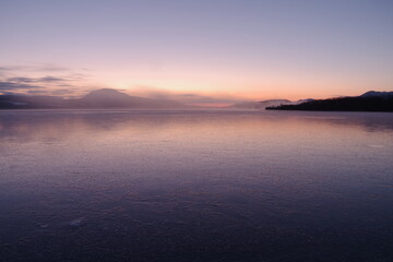 Fototapeta na wymiar 氷に覆われた湖の美しいグラデーションの夜明け。北海道の屈斜路湖。