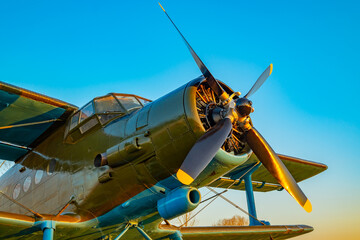 propeller blades of the engine of an old aircraft with part of the fuselage, cabin and wings in khaki green colors