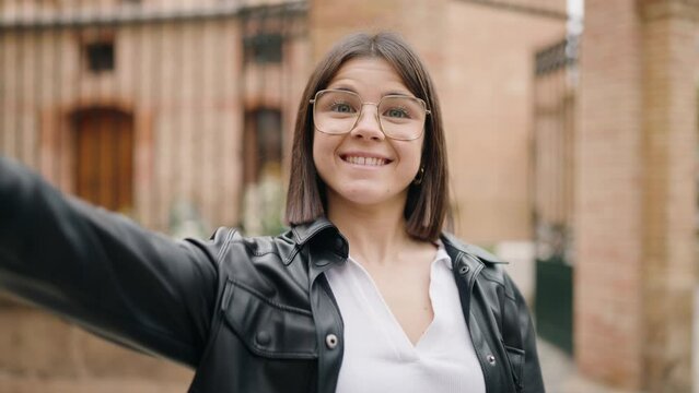 Young hispanic woman smiling confident saying hello standing at street