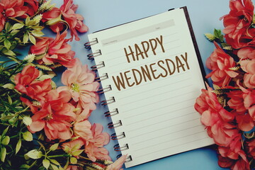 Happy Wednesday typography text on paper notebook flat lay on blue background