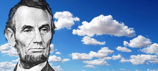 Abraham Lincoln $5 looking sad with blue sky and clouds