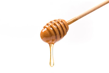 Honey dripping from honey dipper on white background