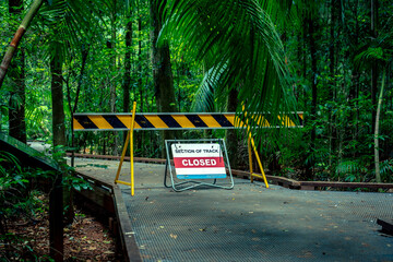 Road Closed sign blocking the road to a walking track in a forest