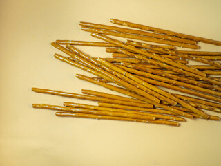 Salted sticks. Confectionery on the table. Salty baked goods. Snack for beer. Dough product on a beige background. Not a healthy diet