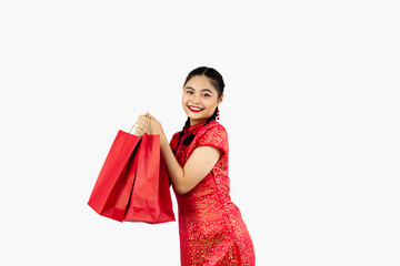 Asian girl in red traditional oriental costume holding shopping bags isolated on white background. Chinese new year in shopping concept style.