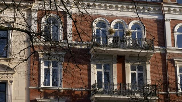 Zoom Out From Residential Red Brick Building, Naked Tree Branches Waving