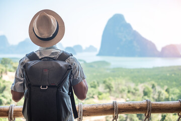 Happy traveler man enjoy Phang Nga bay view point, alone Tourist relaxing at Samet Nang She, near Phuket in Southern Thailand. Southeast Asia travel, trip and summer vacation concept - obrazy, fototapety, plakaty