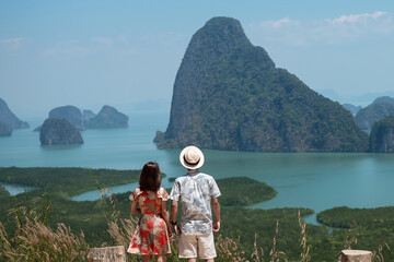 Happy couple traveler enjoy Phang Nga bay view point, Tourists relaxing at Samet Nang She, near Phuket in Southern Thailand. Southeast Asia travel, trip, love, together and summer vacation concept