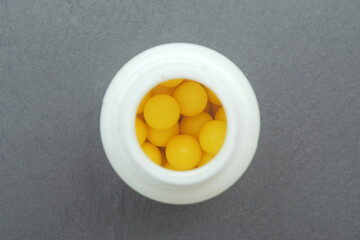 round vitamin c tablets in a jar top view