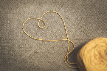 Heart of yarn ball for sweetheart. A lot of colorful wool balls of knitted yarn on a wood background. The concept of handmade work. Balls of alpaca wool. Valentine's day concept. 14 February love day.