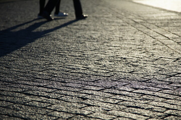 Cobblestone sidewalks of a city street in the evening of the setting sun