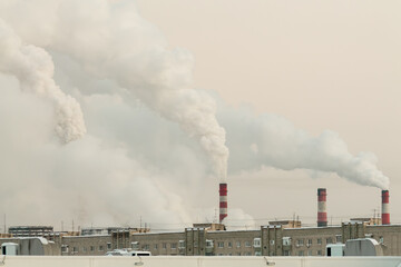 industrial chimneys with heavy white smoke causing air pollution problem