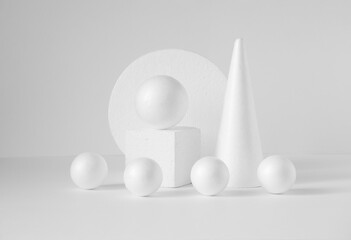 Monochrome composition of various 3d geometric shapes. White balls of different sizes, cube, cone,...
