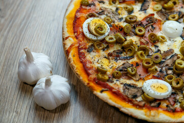 pizza prosciutto e funghi with green olives and boiled egg