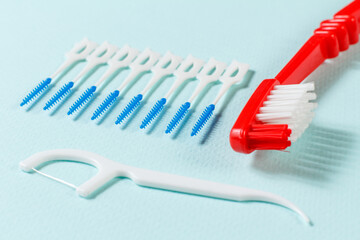 Close-up toothbrush and flossing toothpick on the blue background