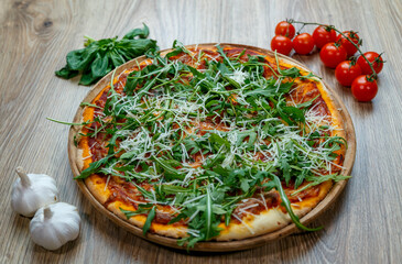 pizza with ham, arugula, tomato sauce and shredded mozzarella