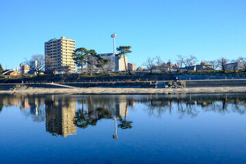 Naklejka premium A beautiful view of the downtown skyline of Okazaki, reflecting in the Otagawa River below. Architectural scenery around Okazaki park, Shizuoka, Japan