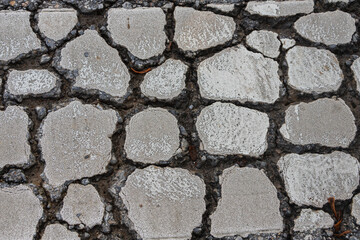 Close-up of a street  gray   road with raised details. Tile pattern