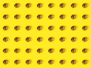 The easter background with the quail brown eggs pattern on the trendy yellow background.