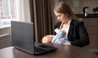 Young caucasian mother working remotely on laptop at home breastfeeding baby, caring and feeding newborn, happy motherhood - obrazy, fototapety, plakaty