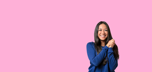 Happy young woman with a beautiful smile and clasped hands
