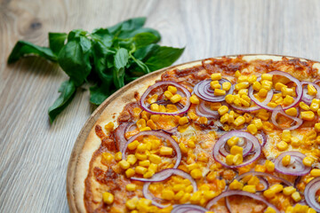 pizza with ham, corn, onion rings and mozzarella